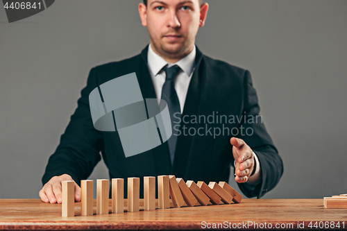 Image of Man and wooden cubes on table. Management concept