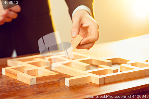 Image of Man and wooden cubes on table. Management concept