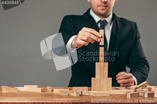 Image of Man and wooden cubes on table. Management concept