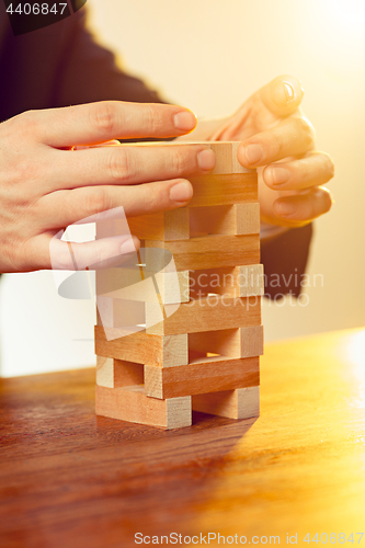 Image of Man and wooden cubes on table. Management concept