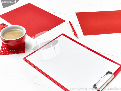 Image of Office table desk with set of colorful supplies, white blank note pad, cup, pen on white background.