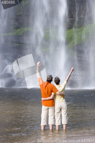 Image of Couple in front of a tropical waterfall