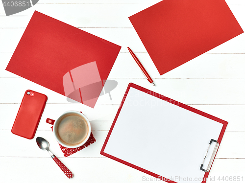 Image of Office table desk with set of colorful supplies, white blank note pad, cup, pen on white background.
