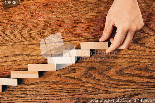 Image of Man and wooden cubes on table. Management and marketing concepts