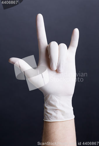Image of Male hand in latex glove (love sign)