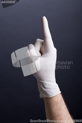 Image of Male hand in latex glove (finger up)