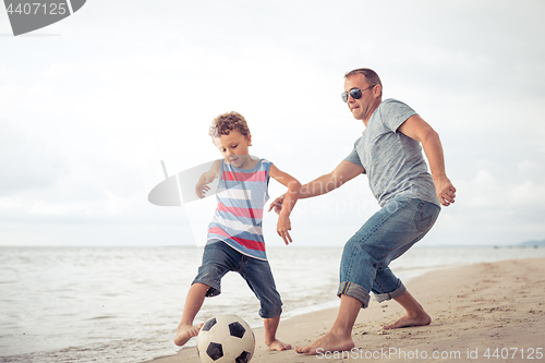 Image of Father and son  playing on the beach at the day time.