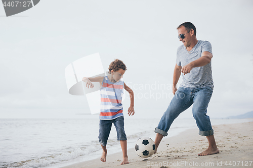 Image of Father and son  playing on the beach at the day time.