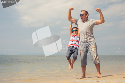 Image of Father and son  playing on the beach at the day time.