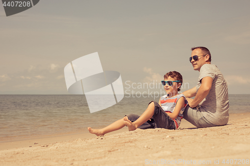 Image of Father and son  playing on the beach at the day time.