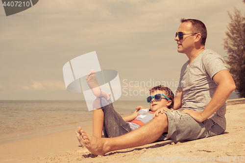 Image of Father and son  playing on the beach at the day time.