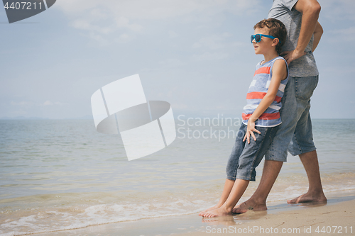 Image of Father and son  playing on the beach at the day time.