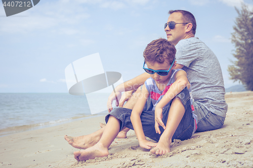 Image of Portrait of young sad little boy and father sitting outdoors at 