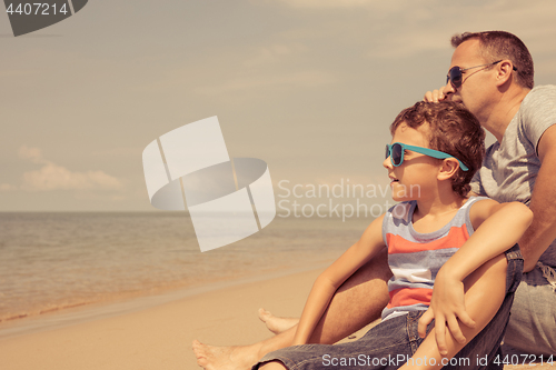 Image of Father and son  playing on the beach at the day time.