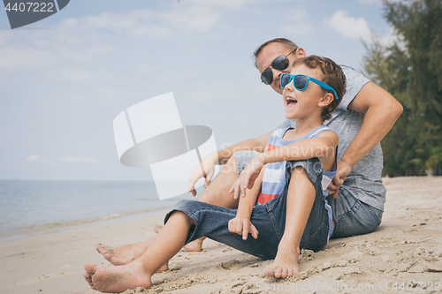 Image of Father and son  playing on the beach at the day time.