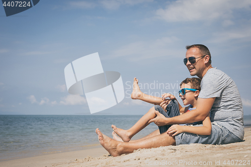 Image of Father and son  playing on the beach at the day time.