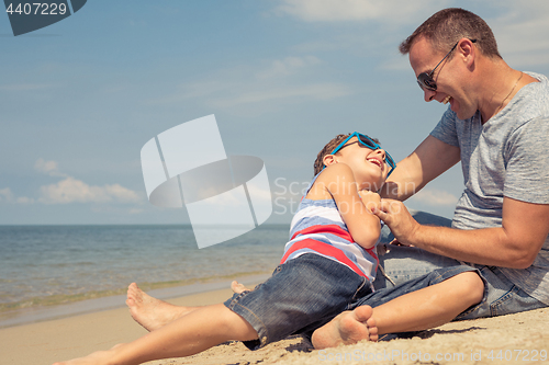 Image of Father and son  playing on the beach at the day time.