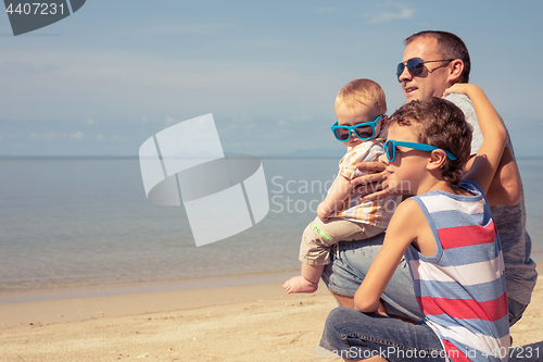 Image of Father and children  playing on the beach at the day time.