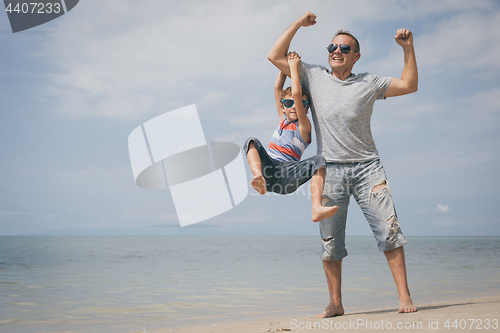 Image of Father and son  playing on the beach at the day time.