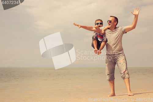 Image of Father and son  playing on the beach at the day time.