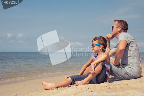 Image of Father and son  playing on the beach at the day time.