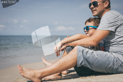 Image of Father and son  playing on the beach at the day time.