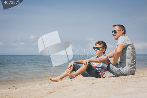 Image of Father and son  playing on the beach at the day time.