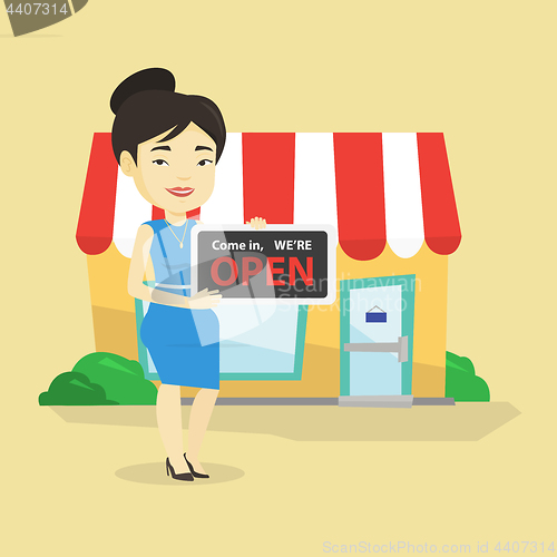 Image of Female shop owner holding open signboard.