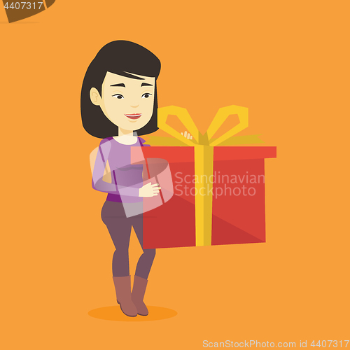 Image of Joyful asian woman holding box with gift.