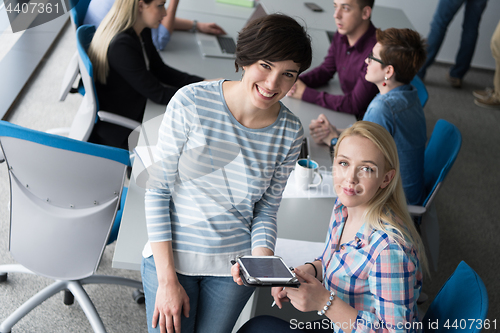 Image of Pretty Businesswomen Using Tablet In Office Building during conf