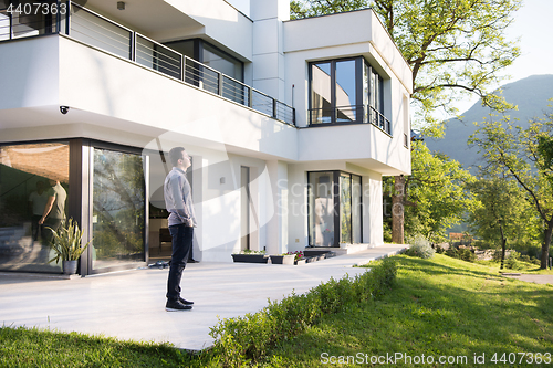 Image of man in front of his luxury home villa