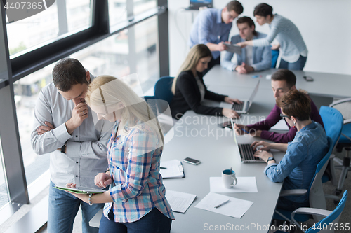 Image of Two Business People Working With Tablet in office