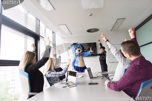 Image of boss dresed as bear having fun with business people in trendy of