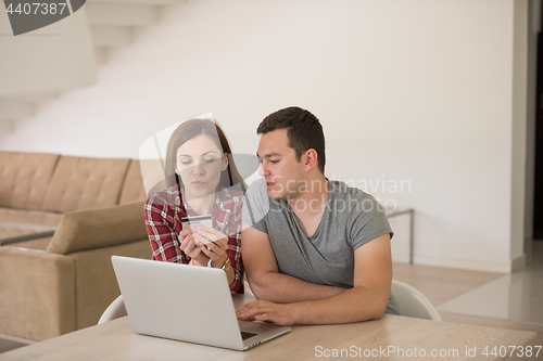 Image of happy young couple buying online