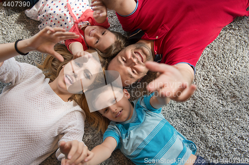 Image of happy family lying on the floor