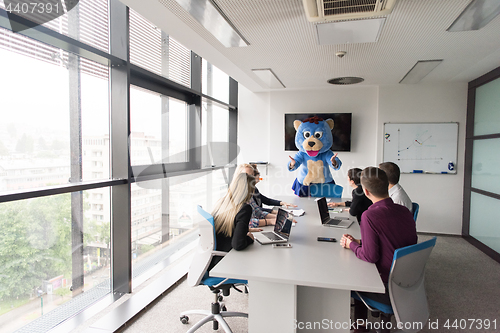 Image of boss dresed as bear having fun with business people in trendy of