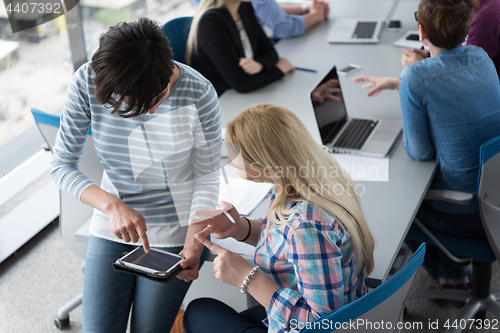 Image of Pretty Businesswomen Using Tablet In Office Building during conf