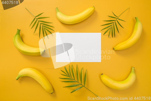 Image of Bananas, palm leaves and blank paper sheet