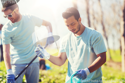 Image of volunteers with garbage bags cleaning park area