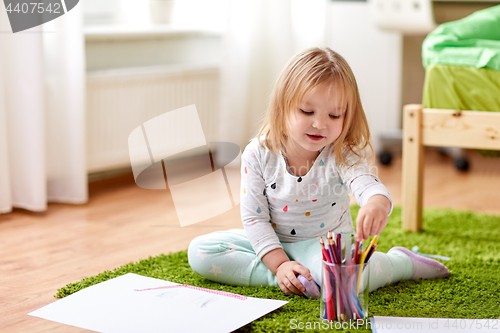 Image of happy little girl with crayons drawing at home