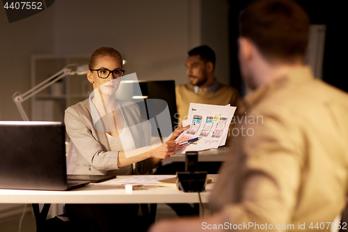 Image of workers with user interface mockup at night office