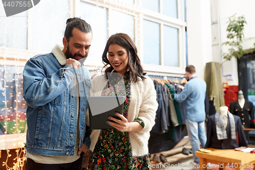 Image of couple with tablet pc at vintage clothing store