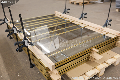 Image of mirror panels with bar clamps at furniture factory