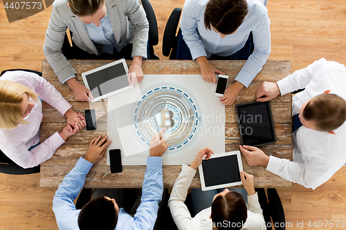 Image of business team with bitcoin holgram at table