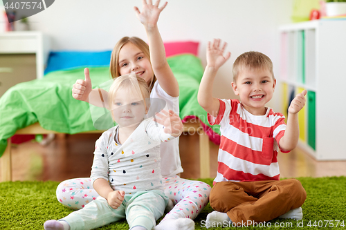 Image of group of happy kids sitting on floor at home