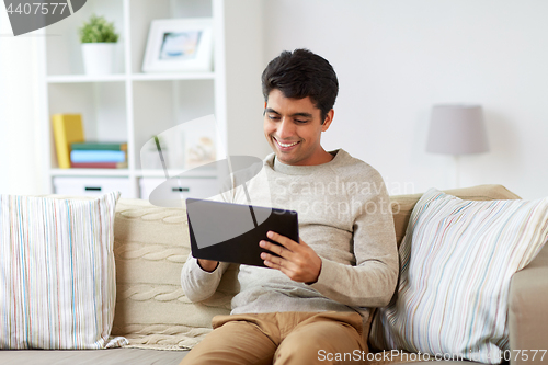 Image of smiling man with tablet pc at home