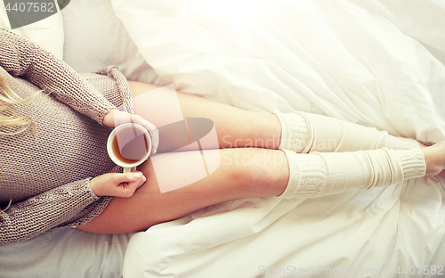 Image of close up of woman with tea cup in bed