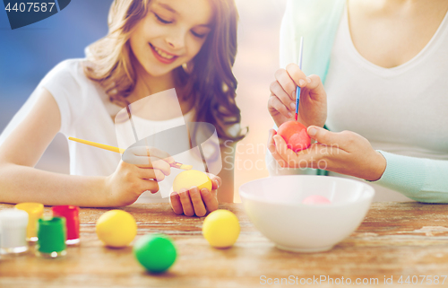 Image of daughter and mother coloring easter eggs