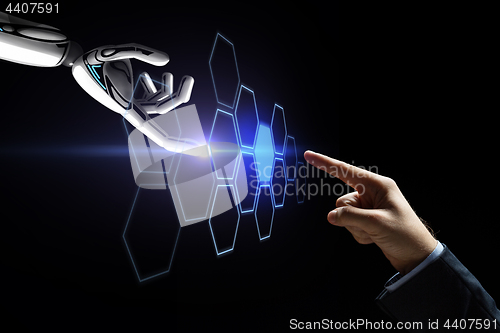 Image of robot and human hand touching network hologram