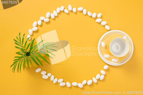 Image of Frame made of white chocolate, palm leaves and yellow teacup